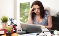 Overworked businesswoman sitting at a messy desk Royalty Free Stock Photo