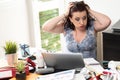 Overworked businesswoman sitting at a messy desk Royalty Free Stock Photo