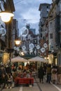 People walk and relax at night on a street decorated with lanterns and luminous balloons on the background of historic buildings i Royalty Free Stock Photo