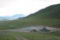 Ovoo in the mountains of Mongolia on the pass. Car with a trailer, motorcyclist and passenger car nearby