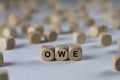 Owe - cube with letters, sign with wooden cubes Royalty Free Stock Photo