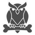 Owl perched on bone solid icon, halloween concept, owl and bone sign on white background, scary bird icon in glyph style