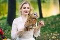 The owl sits on the girl`s hand. Soft focus on owl. The bride with the owl.
