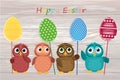 Owls keep Easter decorated eggs on a stick. Multicolored. Vector