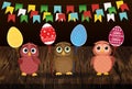 Owls keep Easter decorated eggs on a stick. Multicolored. Vector