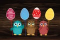 Owls keep Easter decorated eggs on a stick. Multicolored. Vector