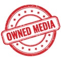 OWNED MEDIA text on red grungy round rubber stamp