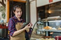 The owner is checking out the bakery. a tablet in hand Check orders according to customer orders whether the items are ready to Royalty Free Stock Photo