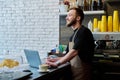 Owner coffee shop worker young male with laptop on the counter