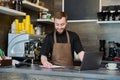 Owner coffee shop worker young male with laptop on the counter