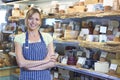 Owner Of Delicatessen Standing Next To Cheese Display Royalty Free Stock Photo