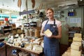 Owner Of Delicatessen Standing In Shop Holding Cheese Royalty Free Stock Photo