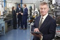 Owner Of Engineering Factory Using Digital Tablet With Staff In