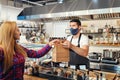 Small business owner with serving takeaway food to customer at counter in fast food restaurant Royalty Free Stock Photo