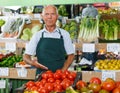 Owner of greengrocery offering fruits and vegetables Royalty Free Stock Photo