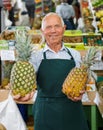 Owner of greengrocery offering fruits and vegetables Royalty Free Stock Photo