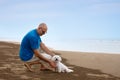 Owner looking to his dog at the beach Royalty Free Stock Photo