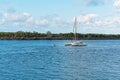 Owner Motoring Towards Moored Catamaran In River Royalty Free Stock Photo