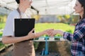 The owner of an organic vegetable farm joins hands with the capitalist to congratulate together the trading of produce