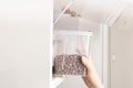 the owner puts the pet food in the container box into the cupboard for proper storage of dog feed in a dry, dark place