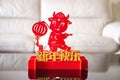 Ox mascot with lantern in front of a sofa as symbol of Chinese New Year of the Ox 2021 the Chinese means happy Chinese new year