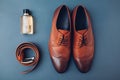 Oxford male brogues shoes with accessories. Men`s fashion. Classical brown leather footwear with belt and perfume Royalty Free Stock Photo