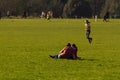 A young caucasian couple is having some leisure time as they sit on the grass and relax in the university park of Oxford Universit