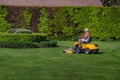 Senior citizen riding lawn mower in a garden Royalty Free Stock Photo