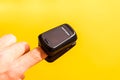 Oximeter on a finger of a patient, isolated on yellow background Royalty Free Stock Photo