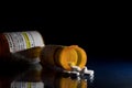 Macro of oxycodone opioid tablets with prescription bottles against dark background