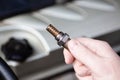 Oxygen sensor for gasoline and diesel engines in the hand against car engine. Mechanic holds oxygen sensor. lambda probe Royalty Free Stock Photo