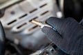 Oxygen sensor for gasoline and diesel engines in the hand against car engine. Mechanic holds oxygen sensor. lambda probe Royalty Free Stock Photo