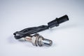 The oxygen sensor is a new lambda sensor. Spare parts on the car on a gray gradient background
