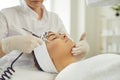 Hands of woman cosmetologist making apparatus procedure of facial oxygen therapy for young woman Royalty Free Stock Photo