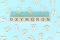 Oxymoron figure of speech concept in English grammar class lesson. Wooden blocks typography flat lay Royalty Free Stock Photo