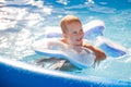 Boy happy swimming in a pool. The boy is happily swimming in the pool on an inflatable circle in the form of a star