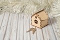 oy wooden house and two keys on a wooden table decorated for New Year or XMAS