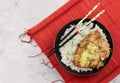 Oyakodon in a bowl boiled rice with chinese chopsticks on a bamboo mat on a light gray background. Royalty Free Stock Photo