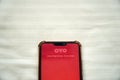 Oyo hotel chain logo displayed in mobile phone on bed Royalty Free Stock Photo