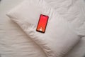 Oyo hotel chain logo displayed in mobile phone on pillow