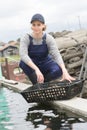 Oyster farm worker posing with basket