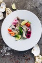 Oysters on a dish decorated with flowers on a gray background. Aphrodisiacs.