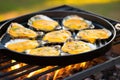 oysters on grill pan, small dish of golden garlic sauce