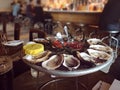 Oysters on ice plate served with lemon and sauce in the oyster bar.