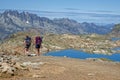 Hikers walk on paths over the lakes of Grandes Rousses mountain range