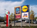 Aldi Lidl DM-drogerie and a pharmacy signpost in front of stores Royalty Free Stock Photo