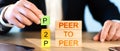 p2p concept. man stacks wooden blocks in the inscription p2p. Royalty Free Stock Photo