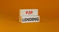 P2P peer to peer lending symbol. Concept words P2P lending on wooden blocks on a beautiful orange background. Business and P2P