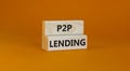 P2P peer to peer lending symbol. Concept words P2P lending on wooden blocks on a beautiful orange background. Business and P2P