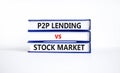 P2P, peer to peer lending vs stock market symbol. Concept words `P2P lending vs stock market` on books. Beautiful white backgrou